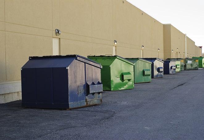 a group of dumpsters lined up along the street ready for use in a large-scale construction project in Elberon